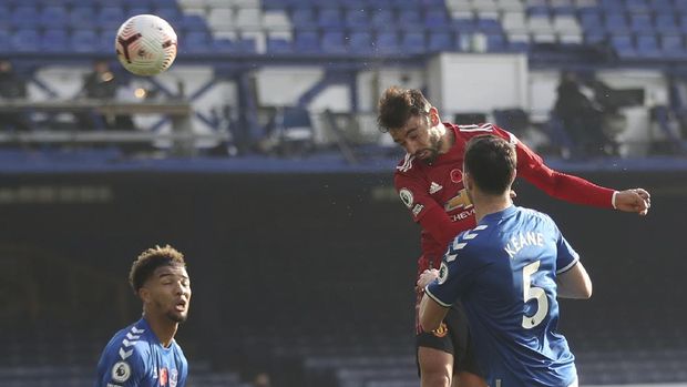 Manchester United's Bruno Fernandes, top, scores his side's opening goal during the English Premier League soccer match between Everton and Manchester United at the Goodison Park stadium in Liverpool, England, Saturday, Nov. 7, 2020. (Carl Recine/Pool via AP)
