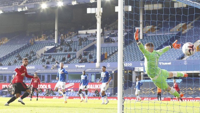 Manchester Uniteds Bruno Fernandes, left, scores his sides opening goal during the English Premier League soccer match between Everton and Manchester United at the Goodison Park stadium in Liverpool, England, Saturday, Nov. 7, 2020. (Carl Recine/Pool via AP)