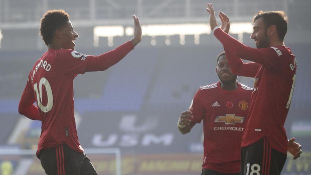 Manchester United's Bruno Fernandes, right, celebrates after scoring his side's second goal during the English Premier League soccer match between Everton and Manchester United at the Goodison Park stadium in Liverpool, England, Saturday, Nov. 7, 2020. (Carl Recine/Pool via AP)