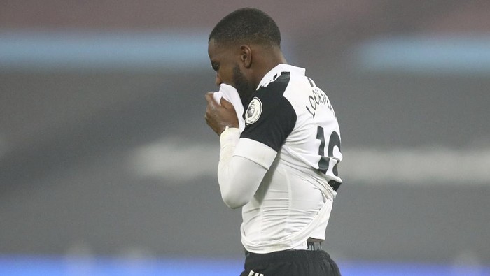 Fulhams Ademola Lookman walks from the pitch and wipes his face with his shirt, he failed to score from the penalty spot during the English Premier League soccer match between West Ham United and Fulham at the London stadium in London, Saturday, Nov.7, 2020. (Julian Finney/Pool via AP)
