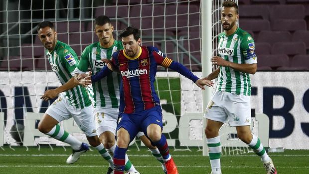 Barcelona's Lionel Messi, second right, is challenged by Betis' Guido Rodriguez during the Spanish La Liga soccer match between FC Barcelona and Betis at the Camp Nou stadium in Barcelona, Spain, Saturday, Nov. 7, 2020. (AP Photo/Joan Monfort)