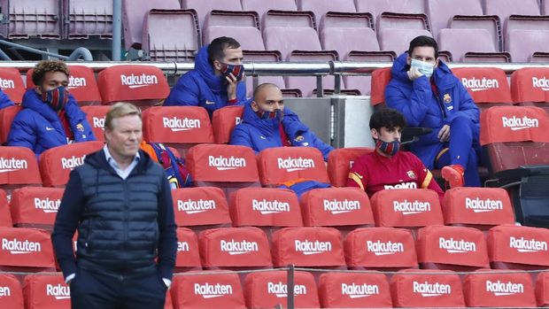 Barcelona's Lionel Messi, right, sits on the bench as Barcelona's head coach Ronald Koeman stands on the side line during the Spanish La Liga soccer match between FC Barcelona and Betis at the Camp Nou stadium in Barcelona, Spain, Saturday, Nov. 7, 2020. (AP Photo/Joan Monfort)