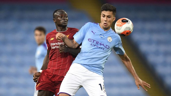 MANCHESTER, ENGLAND - JULY 02: Sadio Mane of Liverpool battles for possession with Rodrigo of Manchester City during the Premier League match between Manchester City and Liverpool FC at Etihad Stadium on July 02, 2020 in Manchester, England. Football Stadiums around Europe remain empty due to the Coronavirus Pandemic as Government social distancing laws prohibit fans inside venues resulting in all fixtures being played behind closed doors. (Photo by Peter Powell/Pool via Getty Images)