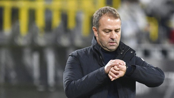 Munich coach Hansi Flick looks at his watch during the German Bundesliga soccer match between Borussia Dortmund and Bayern Munich at Signal Iduna Park, in Dortmund, Germany, Saturday, Nov. 7, 2020. (Bernd Thissen/Pool via AP)