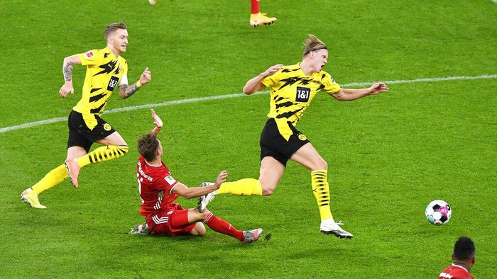 Dortmunds Marco Reus, left, Dortmunds Erling Haaland, right, and Bayerns Joshua Kimmich challenge for the ball during the German Bundesliga soccer match between Borussia Dortmund and Bayern Munich in Dortmund, Germany, Saturday, Nov. 7, 2020. (AP Photo/Martin Meissner, Pool)
