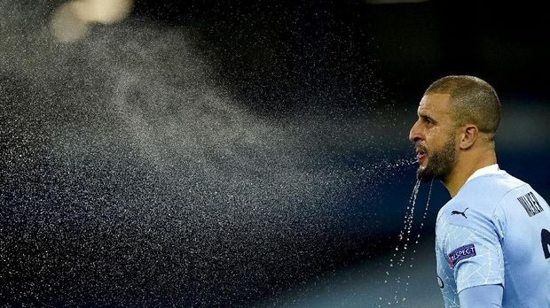 Manchester City's Kyle Walker refreshes himself before the Champions League group C soccer match between Manchester City and Olympiakos at the Etihad stadium in Manchester, England, Tuesday, Nov. 3, 2020. (AP Photo/Dave Thompson)