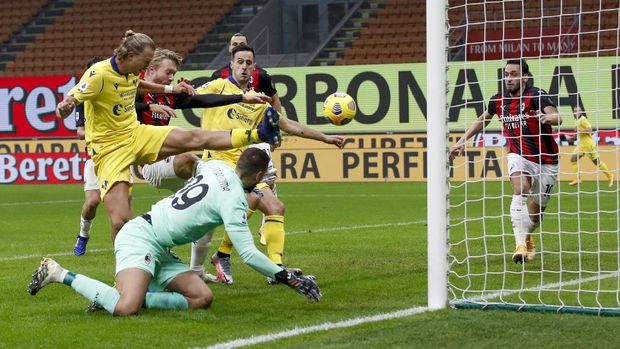 Verona's Antonin Barak, left, scores his side's first goal during a Serie A soccer match between AC Milan and Verona, at the San Siro Stadium, in Milan, Sunday, Nov. 8, 2020. (AP Photo/Antonio Calanni)
