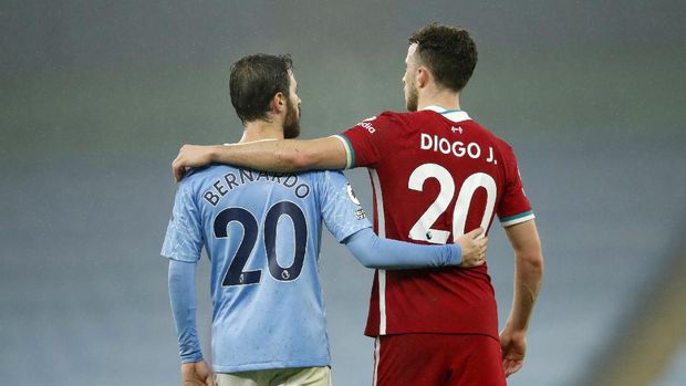 Manchester City's Bernardo Silva, left, and Liverpool's Diogo Jota embrace each other at the end of the English Premier League soccer match between Manchester City and Liverpool at the Etihad stadium in Manchester, England, Sunday, Nov. 8, 2020. (Clive Brunskill/Pool via AP)