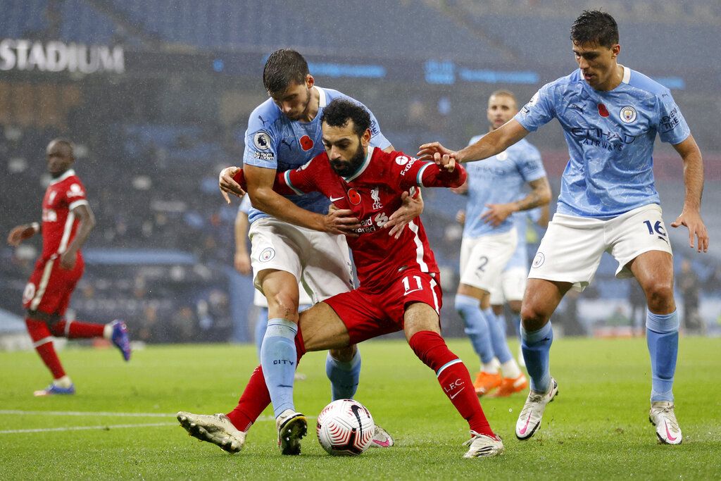 Liverpool's Mohamed Salah, center, vies for the ball with Manchester City's Ruben Dias during the English Premier League soccer match between Manchester City and Liverpool at the Etihad Stadium in Manchester, England, Sunday, November 8, 2020 (Clive Brunskill / Pool via AP)