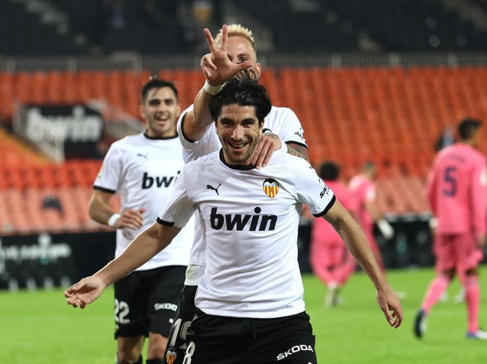 VALENCIA, SPAIN - NOVEMBER 08: Carlos Soler of Valencia celebrates with teammate Uroc Racic after scoring his teams fourth goal  during the La Liga Santander match between Valencia CF and Real Madrid at Estadio Mestalla on November 08, 2020 in Valencia, Spain. Sporting stadiums around Spain remain under strict restrictions due to the Coronavirus Pandemic as Government social distancing laws prohibit fans inside venues resulting in games being played behind closed doors. (Photo by Angel Martinez/Getty Images)