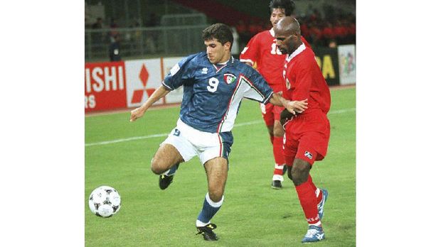 Kuwaiti forward Bashar Abdul Aziz (L) duels with Indonesian defender Aples Tecuari (R) during their Asian Cup match  held in Abu Dhabi stadium 04 December.The match between Kuwait and Indonesia ended  in a tie 2-2. (Photo by RABIH MOGHRABI / AFP)