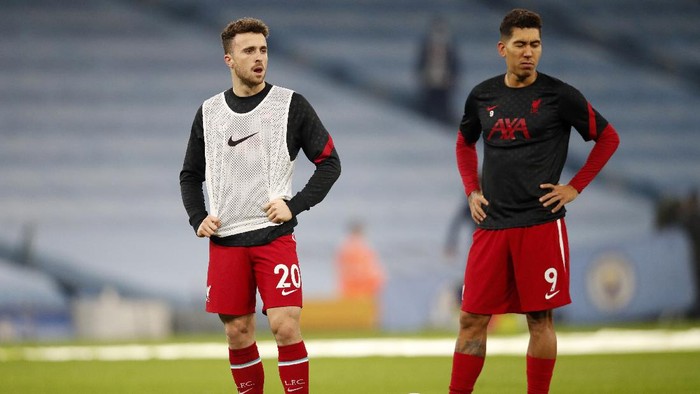 Liverpools Diogo Jota and Liverpools Roberto Firmino, right, stand on the pitch during warmup before the English Premier League soccer match between Manchester City and Liverpool at the Etihad stadium in Manchester, England, Sunday, Nov. 8, 2020. (Clive Brunskill/Pool via AP)