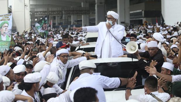 Indonesian Islamic cleric and the leader of Islamic Defenders Front Rizieq Shihab, center, speaks to his followers upon arrival from Saudi Arabia at Soekarno-Hatta International Airport in Tangerang, Indonesia, Tuesday, Nov. 10, 2020. Thousands of followers of the firebrand cleric joyfully welcomed him at an the airport as he returned home from a 3-year exile in Saudi Arabia after criminal charges including a pornography case were dropped. (AP Photo)