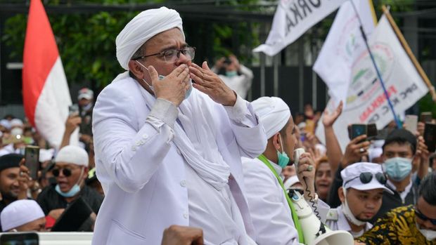 Rizieq Shihab (C), leader of the Indonesian hardline organisation FPI (Front Pembela Islam or Islamic Defenders Front), greets supporters at their headquarters in Jakarta on November 10, 2020, following his return from Saudi Arabia. (Photo by BAY ISMOYO / AFP)