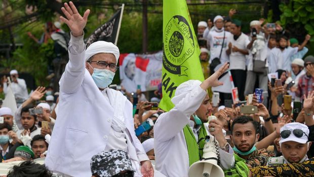 Rizieq Shihab (C), leader of the Indonesian hardline organisation FPI (Front Pembela Islam or Islamic Defenders Front), greets supporters at their headquarters in Jakarta on November 10, 2020, following his return from Saudi Arabia. (Photo by BAY ISMOYO / AFP)