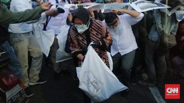 Wali Kota Surabaya Tri Rismaharini mendatangi lokasi aksi unjuk rasa massa Gerakan Tolak Omnibus Law (Getol) Jawa Timur dan memungut sampah diiringi sejumlah jajarannya, Surabaya, 10 November 2020. (CNNIndonesia/Farid)