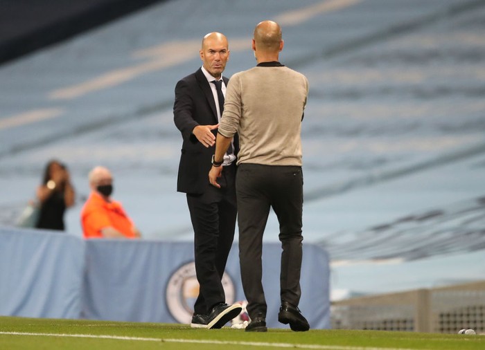 MANCHESTER, ENGLAND - AUGUST 07: Pep Guardiola, Manager of Manchester City shakes hands with Zinedine Zidane, Head Coach of Real Madrid following the UEFA Champions League round of 16 second leg match between Manchester City and Real Madrid at Etihad Stadium on August 07, 2020 in Manchester, England. (Photo by Nick Potts/Pool via Getty Images)