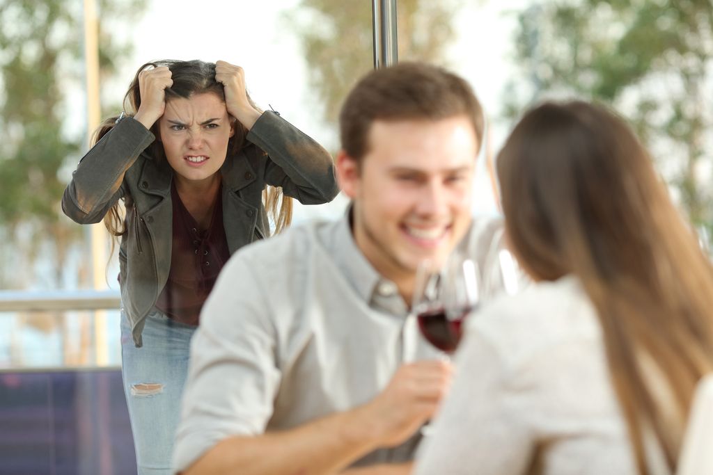 Disloyal boyfriend caught by his angry girlfriend dating with another girl in a restaurant