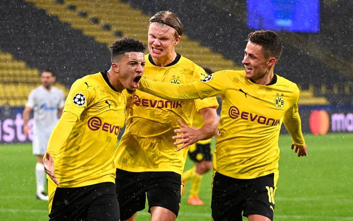 DORTMUND, GERMANY - OCTOBER 28: Jadon Sancho of Borussia Dortmund celebrates with teammates Thorgan Hazard and Erling Haaland  after scoring his teams first goal from the penalty spot during the UEFA Champions League Group F stage match between Borussia Dortmund and Zenit St. Petersburg at Signal Iduna Park on October 28, 2020 in Dortmund, Germany. Sporting stadiums around Dortmund remain under strict restrictions due to the Coronavirus Pandemic as Government social distancing laws prohibit fans inside venues resulting in games being played behind closed doors. (Photo by Lukas Schulze/Getty Images)