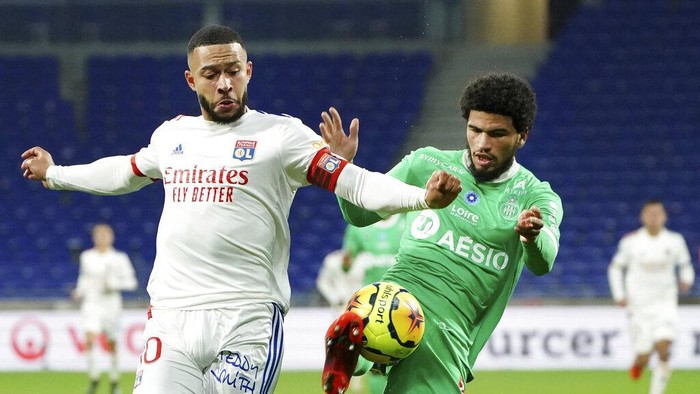 Lyons Memphis Depay, left, challenges for the ball with Saint-Etiennes Charles Nathan Abi, right, during the French League One soccer match between Lyon and Saint-Etienne in Decines, near Lyon, central France, Sunday, Nov. 8, 2020. (AP Photo/Laurent Cipriani)