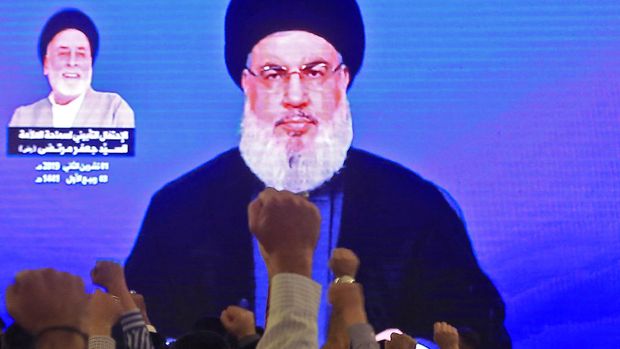 Supporters of Hassan Nasrallah, the head of Lebanon's militant Shiite Muslim Hezbollah movement, watch him speak through a giant screen at a mosque in the Lebanese capital Beirut's southern suburbs on November 1, 2019. (Photo by - / AFP)