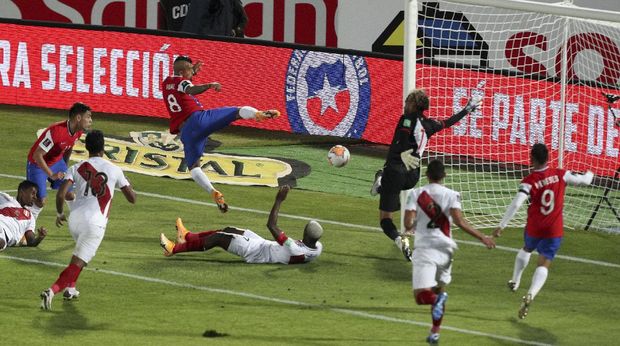 Chile's Arturo Vidal, center above, scores his side's second goal against Peru during a qualifying soccer match for the FIFA World Cup Qatar 2022 in Santiago, Chile, Friday, Nov. 13, 2020. (AP Photo/Esteban Felix)