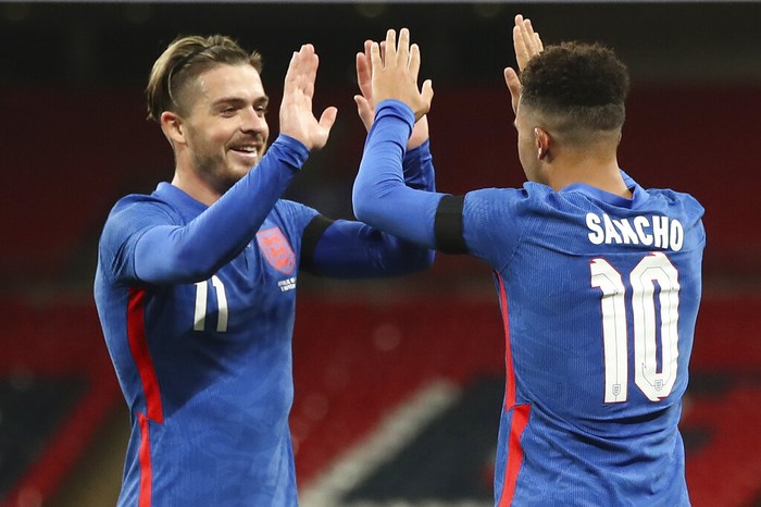 Englands Jadon Sancho, right, celebrates with Jack Grealish after scoring this sides 2nd goal during the international friendly soccer match between England and Ireland at Wembley stadium in London, England, Thursday Nov. 12, 2020. (Nick Potts/Pool via AP)