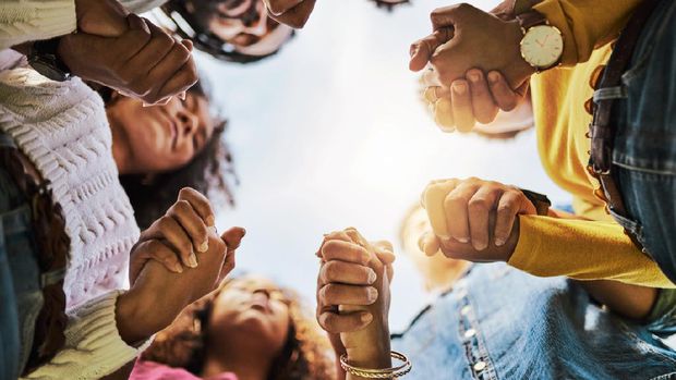 Cropped shot of a group of friends holding hands