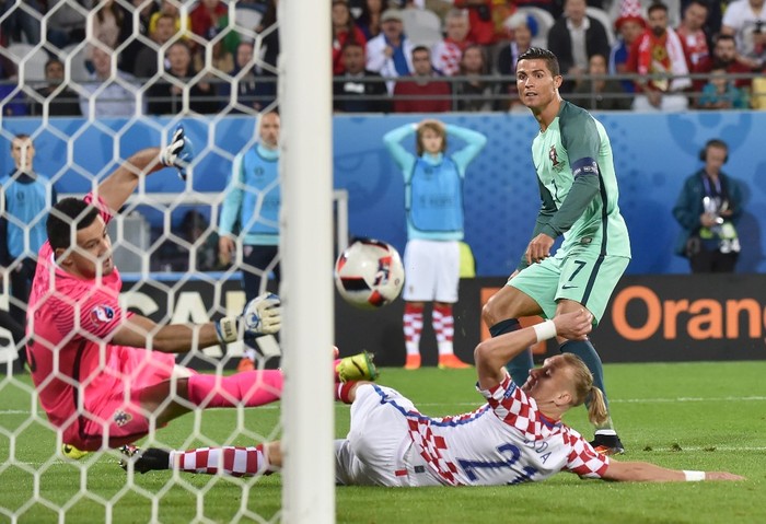 Croatias goalkeeper Danijel Subasic (L) and Croatias defender Domagoj Vida (C) try to stop a goal beside Portugals forward Cristiano Ronaldo during the Euro 2016 round of sixteen football match Croatia vs Portugal, on June 25, 2016 at the Bollaert-Delelis stadium in Lens. (Photo by PHILIPPE HUGUEN / AFP)