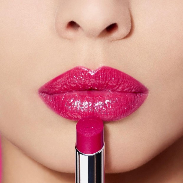 Katie Jane Hughes, menunjukkan langkah pertama untuk pembuatan glass lips, yaitu dengan mengaplikasikan lipstik berwarna merah muda.