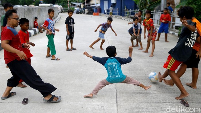 Jalan inspeksi Ciliwung di kawasan Bukit Duri, Jakarta, dimanfaatkan sejumlah anak untuk bermain sepakbola. Hal itu terpaksa dilakukan karena minimnya lahan bermain.
