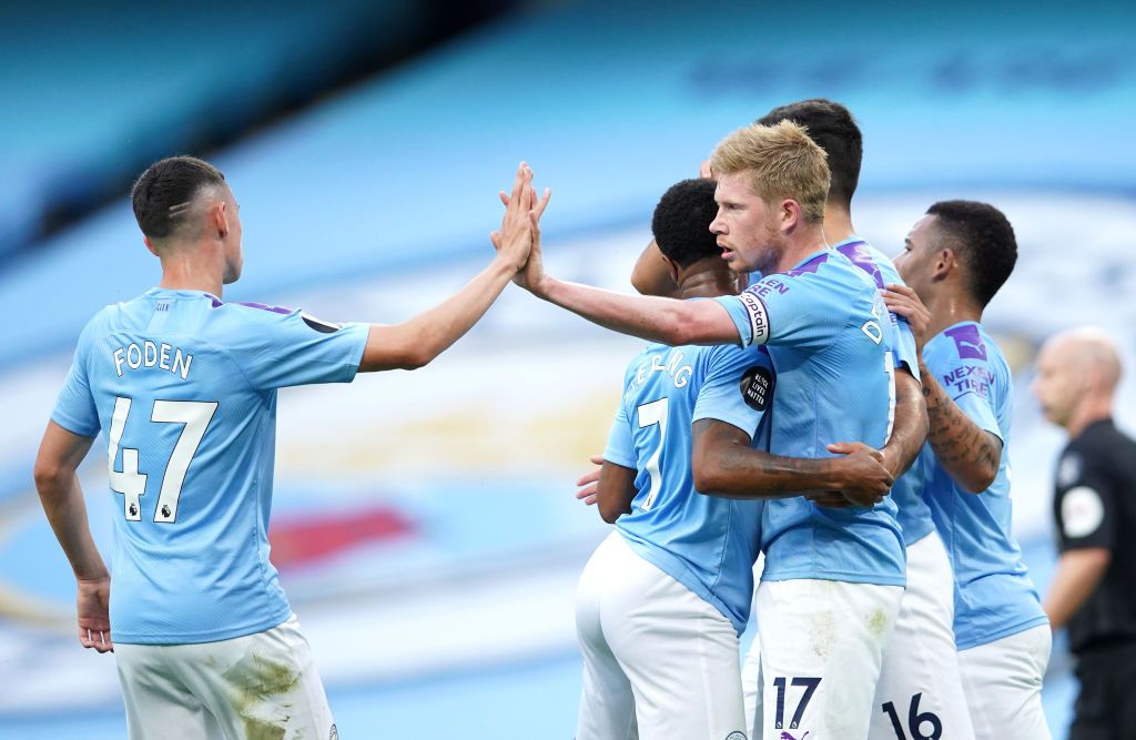 MANCHESTER, ENGLAND - JULY 02: Kevin De Bruyne of Manchester City celebrates with Raheem Sterling and Phil Foden after scoring his team's first goal during the Premier League match between Manchester City and Liverpool FC at Etihad Stadium on July 02, 2020 in Manchester, England. Football Stadiums around Europe remain empty due to the Coronavirus Pandemic as Government social distancing laws prohibit fans inside venues resulting in all fixtures being played behind closed doors. (Photo by Dave Thompson/Pool via Getty Images)