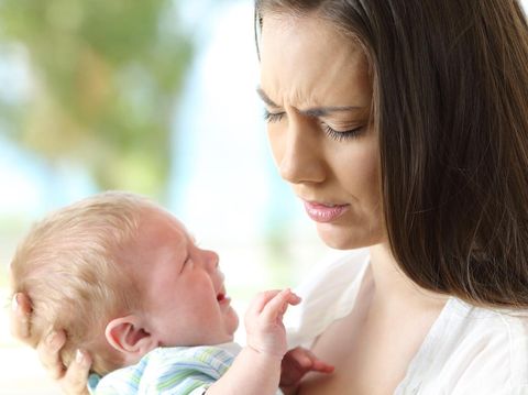 Tired desperate mother and baby crying