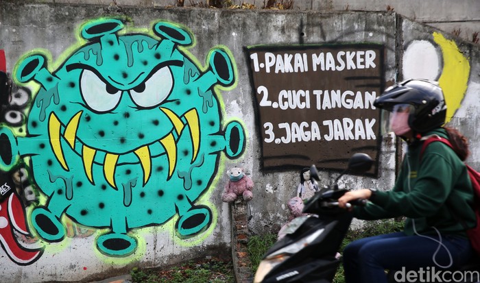 Mural COVID-19 Sarana Edukasi Masyarakat Pengendara melintasi mural bertema COVID 19 di Jalan Cakung Cilincing Barat, Jakarta Timur, Kamis (19/11/2020). Mural masih dianggap menjadi sarana edukasi kesehatan yang tepat bagi warga untuk menjaga diri dari penularan virus Covid 19.