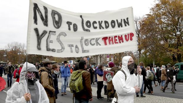 Pendemo Anti Lockdown di Jerman Ditembak Water Canon People attend a protest rally in front of the Brandenburg Gate in Berlin, Germany, Wednesday, Nov. 18, 2020 against the coronavirus restrictions in Germany. Police in Berlin have requested thousands of reinforcements from other parts of Germany to cope with planned protests by people opposed to coronavirus restrictions. (AP Photo/Michael Sohn)