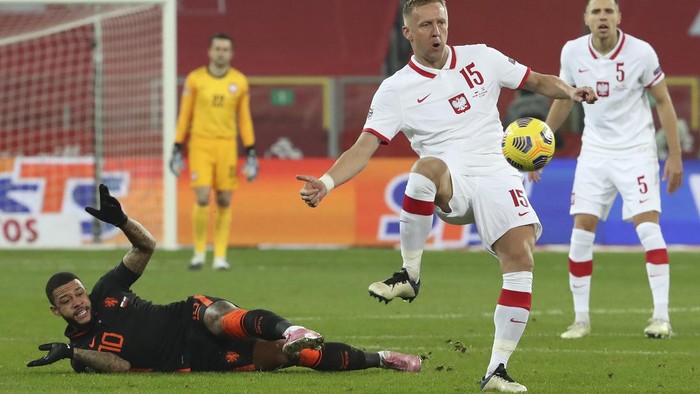 Polands Kamil Glik, center, and Netherlands Memphis Depay, left, vie for the ball during the Nations League soccer match between Poland and The Netherlands at Silesian Stadium in Chorzow, Poland, Wednesday, Nov. 18, 2020. (AP Photo/Czarek Sokolowski)