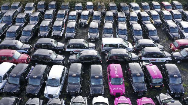 An aerial view shows black London taxi cabs parked up in a field in Epping, north-east of London on November 19, 2020. - Picking up a fare has become so hard for London's legendary black cabs that many taxis are being mothballed. Some taxi drivers who hire their cabs have returned them to fleet companies, which are then forced to store the vehicles in fields around the city. (Photo by Will EDWARDS / AFP) / TO GO WITH AFP STORY BY ANNA MALPAS