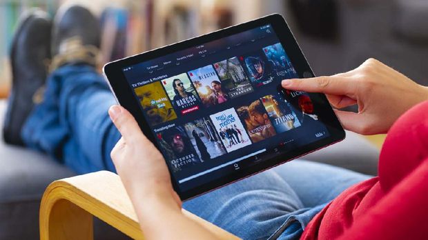 İstanbul, Turkey - July 1 2018: Woman using tablet computer and looking an online streaming platform. The tablet pc is an iPad Air 2, developed by Apple Inc.