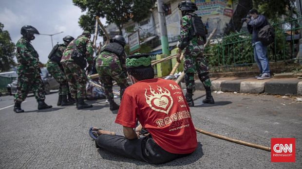 Sejumlah anggota TNI melakukan pencopotan baliho bergambar Rizieq Shihab di kawasan Petamburan, Jakarta, Jumat, 20 November 2020. Pangdam Jaya Mayjen TNI Dudung Abdurachman menyatakan pihaknya bakal mencopot semua baliho pentolan Front Pembela Islam (FPI) Rizieq Shihab yang terpasang sembarangan dan tanpa izin. CNN Indonesia/Bisma Septalisma