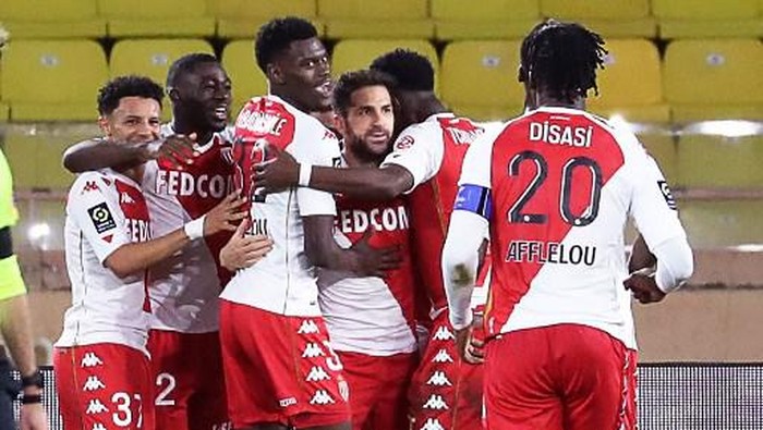 Monacos Spanish midfielder Cesc Fabregas (C) celebrates with teammates after scoring a penalty kickduring the French L1 football match between Monaco (ASM) and Paris Saint-Germain (PSG) at the Louis II Stadium in Monaco on November 20, 2020. (Photo by Valery HACHE / AFP)