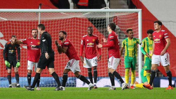 MANCHESTER, ENGLAND - NOVEMBER 21: Juan Mata and Bruno Fernandes of Manchester United confront referee David Coote after he awards West Bromwich Albion a penalty during the Premier League match between Manchester United and West Bromwich Albion at Old Trafford on November 21, 2020 in Manchester, England. Sporting stadiums around the UK remain under strict restrictions due to the Coronavirus Pandemic as Government social distancing laws prohibit fans inside venues resulting in games being played behind closed doors. (Photo by Catherine Ivill/Getty Images)