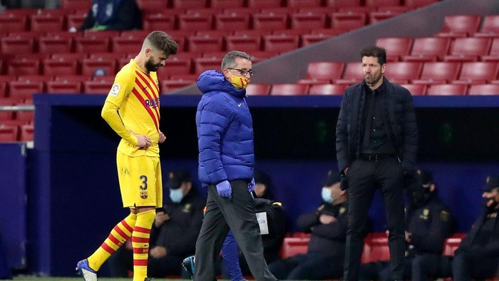 MADRID, SPAIN - NOVEMBER 21: Diego Simeone, Head Coach of Atletico de Madrid looks on as Gerard Pique of FC Barcelona looks dejected following his teams defeat in the La Liga Santander match between Atletico de Madrid and FC Barcelona at Estadio Wanda Metropolitano on November 21, 2020 in Madrid, Spain. Football Stadiums around Europe remain empty due to the Coronavirus Pandemic as Government social distancing laws prohibit fans inside venues resulting in fixtures being played behind closed doors. (Photo by Gonzalo Arroyo Moreno/Getty Images)