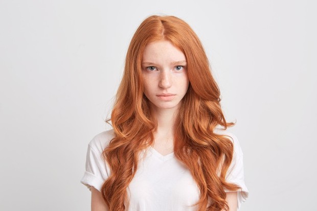 closeup-beautiful-redhead-young-woman-with-wavy-long-hair-freckles-wears-t-shirt-feels-sad-looks-front-isolated-white-wall_295783-945