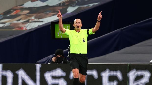 LONDON, ENGLAND - NOVEMBER 21: Referee Mike Dean indicates that he has made his decision following a VAR side field review, then goes on to disallow a Manchester City goal due to a hand ball during the Premier game League match between Tottenham Hotspur and Manchester City at Tottenham Hotspur Stadium on November 21, 2020 in London, England.  Sports stadiums across the UK remain under strict restrictions due to the coronavirus pandemic, as the government's social distancing laws prohibit fans within venues, causing games to be played behind closed doors.  (Photo by Clive Rose / Getty Images)