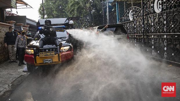 Anggota kepolisian Polda Metro Jaya menggunakan Alat Pelindung Diri (APD) saat melakukan penyemprotan di kawasan Petamburan, Jakarta, Minggu, 22 November 2020. Penyemprotan tersebut dilakukan sebagai upaya pencegahan penyebaran Covid-19. CNN Indonesia/Bisma Septalisma