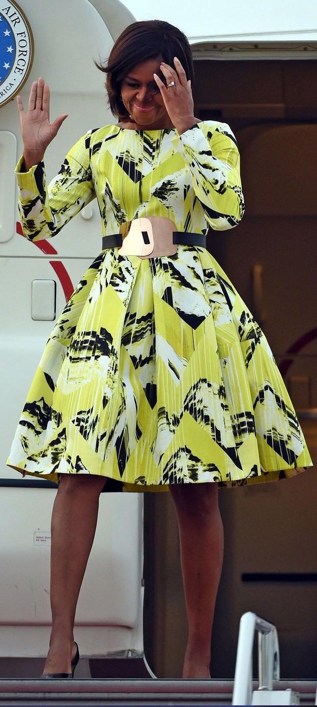 Michelle Obama mengenakan chevron pattern dress dan statement belt.