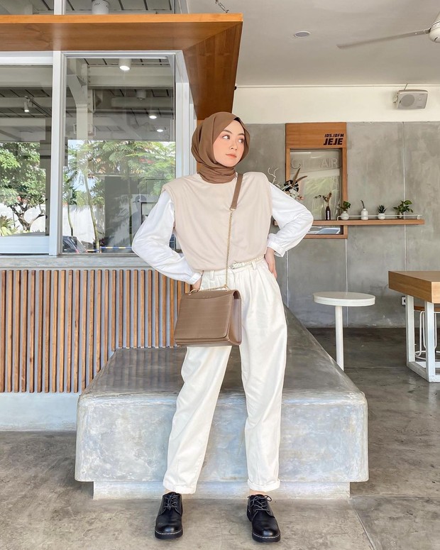Gaya bernuansa earth tone dengan atasan overal dan celana putih/instagram.com/meiraniap
