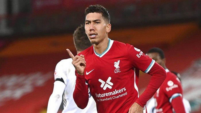 Liverpools Roberto Firmino celebrates after scoring their sides third goal during the English Premier League soccer match between Liverpool and Leicester City at Anfield stadium in Liverpool, England. Saturday, Nov. 22, 2020. (Laurence Griffiths/Pool via AP)