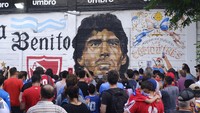 Sebuah mural dengan wajah Maradona didatangi puluhan fans. (Foto: Getty Images/Fernando de Dios)