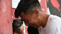 Salah seorang fans menangis di hadapan patung berkepala Maradona. (Foto: Getty Images/Luciano Bisbal)